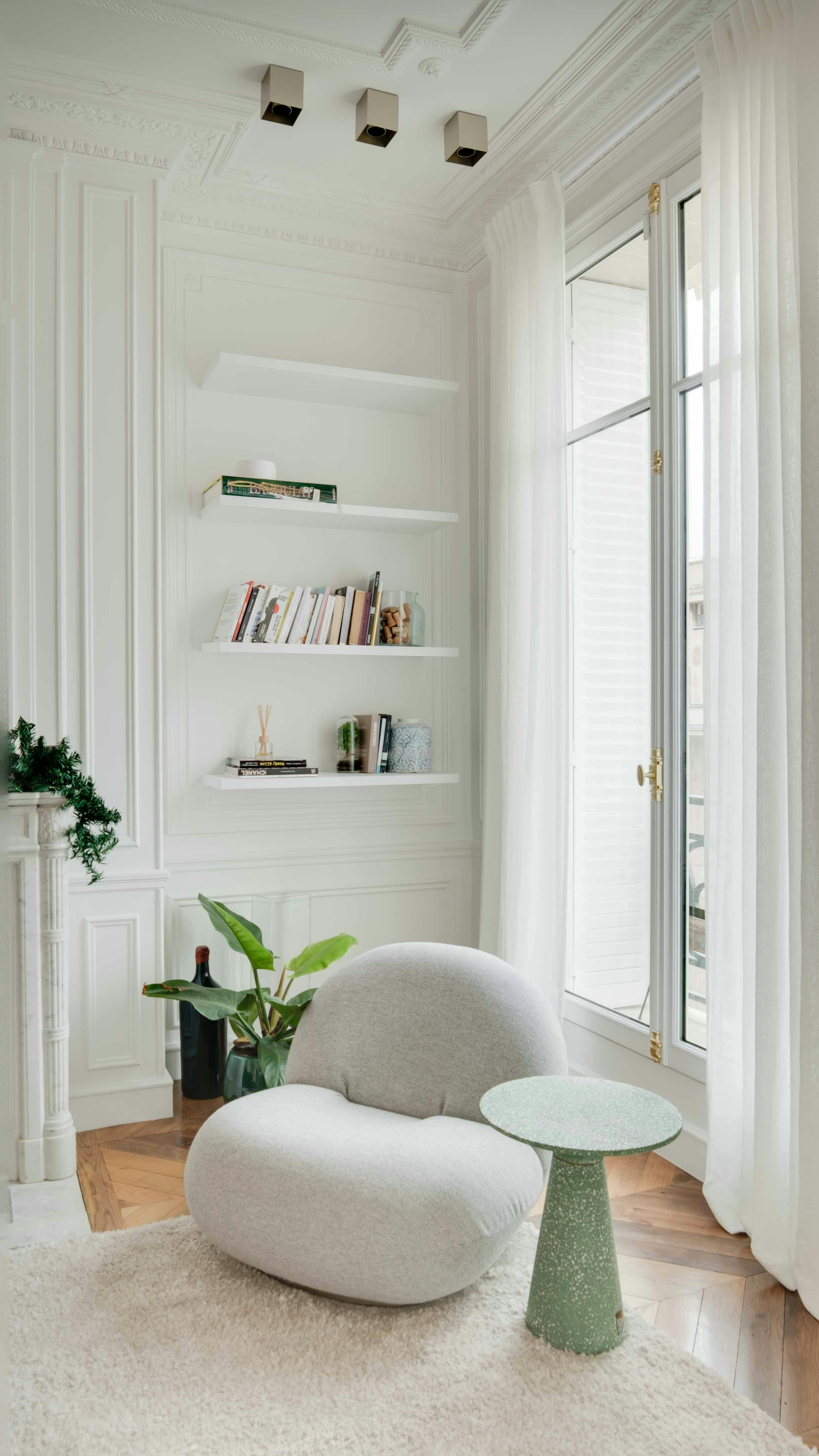 White living room with white shelves and grey chair next to window

decorating ideas