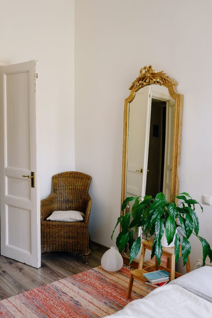 Antique mirror leaning on a wall next to a plant and chair

staging design